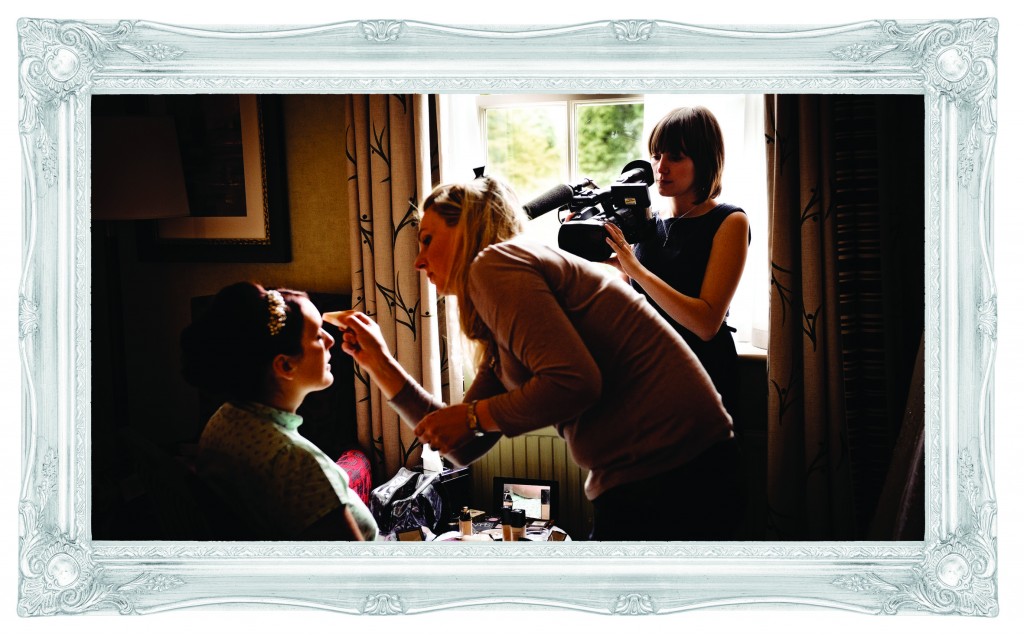 A photograph of Love Gets Sweeter wedding videography filming a bride getting her make-up done in front of a large, bright window at Mottram Hall for her wedding day