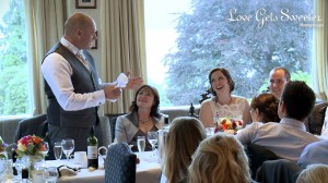 the bride smiles up at her dad during his Father of the Bride speech at their wedding at Langdale Chase Hotel over looking Lake Windermere