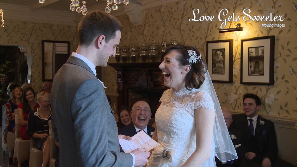 the bride wearing Stewart Parvin laughs along with the guests during the grooms personal vows about loving her more than Liverpool football club at their wedding ceremony at Mitton Hall
