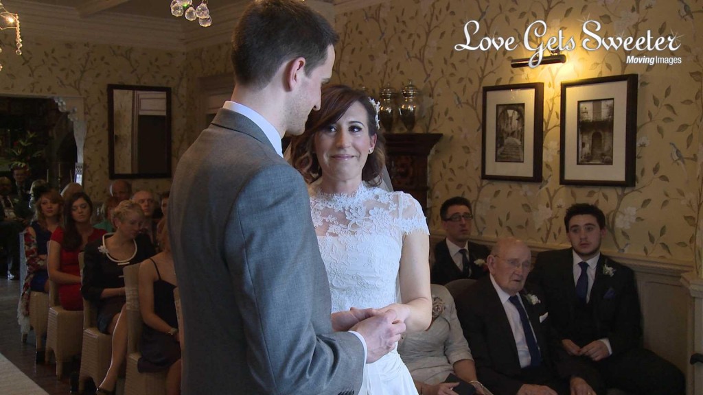 Keri the bride smiles with tears in her eyes as she exchanges wedding rings on her wedding day at Mitton Hall