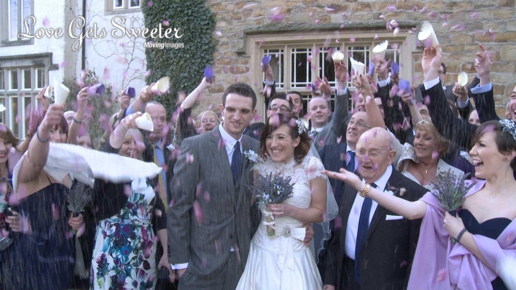the bride and groom are showered in natural purple and cream wedding confetti for the photo and video outside Mitton Hall near Clitheroe