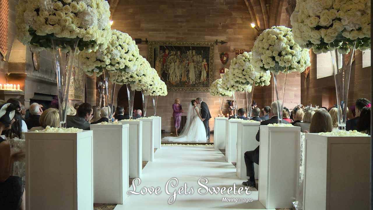 a couple kiss in the great hall at Peckforton castle