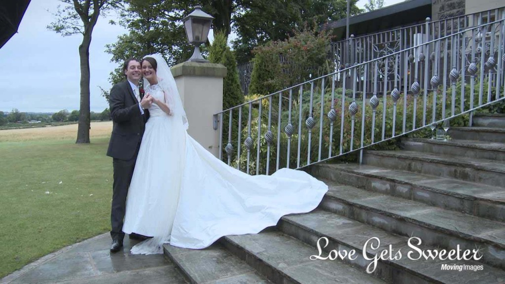 a wedding video still of a very happy and slightly tipsy bride and groom standing on the steps outside West Tower for some photographs with Ian MacMichael in Lancashire