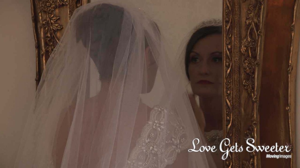 A bride checks she's happy with her earrings in the large gold mirror in the bridal suite at West Tower