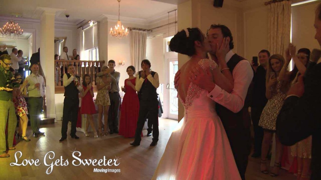 a wide shot from the wedding videographer of the bride and groom having a kiss during their first dance at their west tower wedding reception in Lancashire