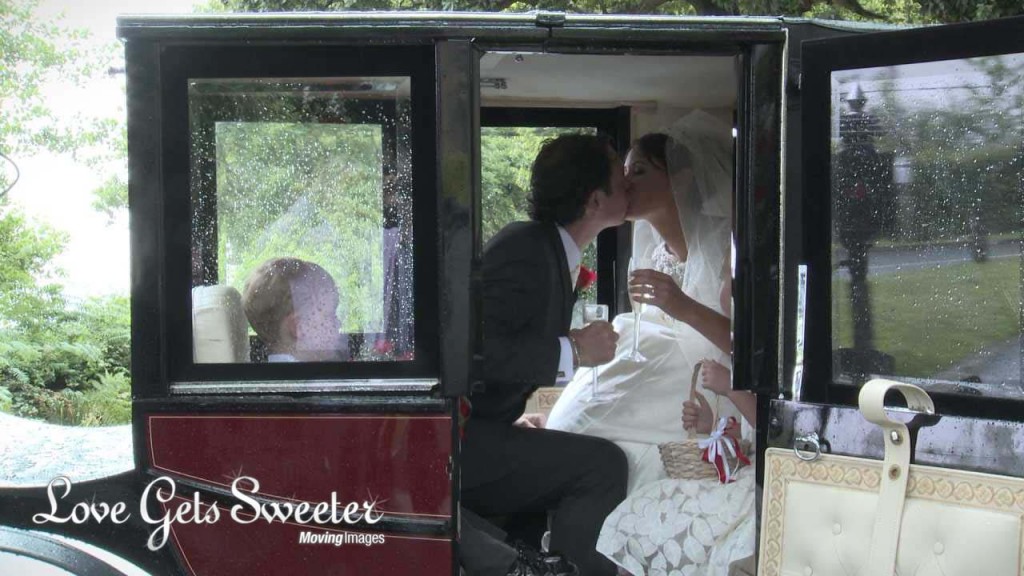 a wedding video still of a bride and groom newlyweds sitting inside their wedding horse and carriage and having a kiss holding their champagne after their wedding ceremony at Dalton Church