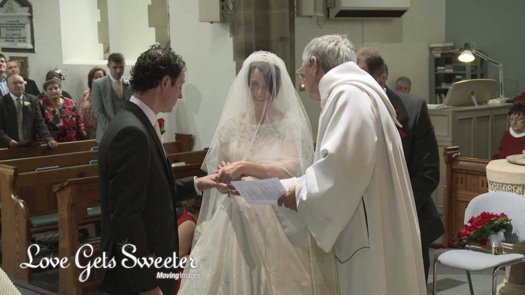 A bride and groom exchange wedding rings in front of the wedding videographer at Dalton St Michaels and All Angels Church in Lancashire