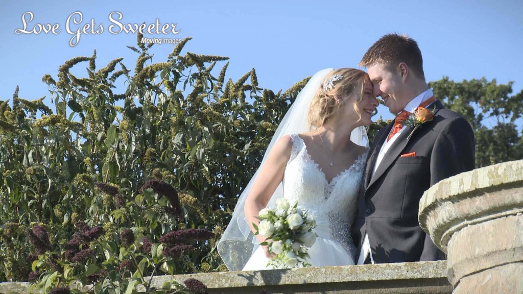 the bride leans in to the groom as they enjoy a laugh and giggle on the terrace at their wedding venue Willington Hall in Cheshire