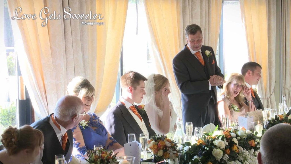 the father of the bride stands to give his wedding speech at willington hall and have the bride in tears as she gets emotional on the wedding video