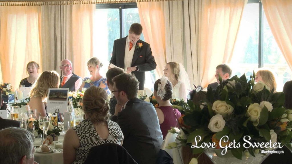 a shot from the wedding video of everyone laughing during the grooms wedding speech at Willington hall