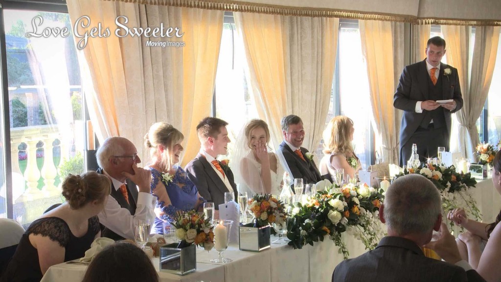 the bride covers her face with her hand as the best man tries to embarrass the groom during his best mans speech at Willington Hall