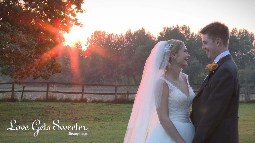 Our bride and groom casually stand and chat in the gardens at Willington Hall as the sun begins to set and the sky turns red