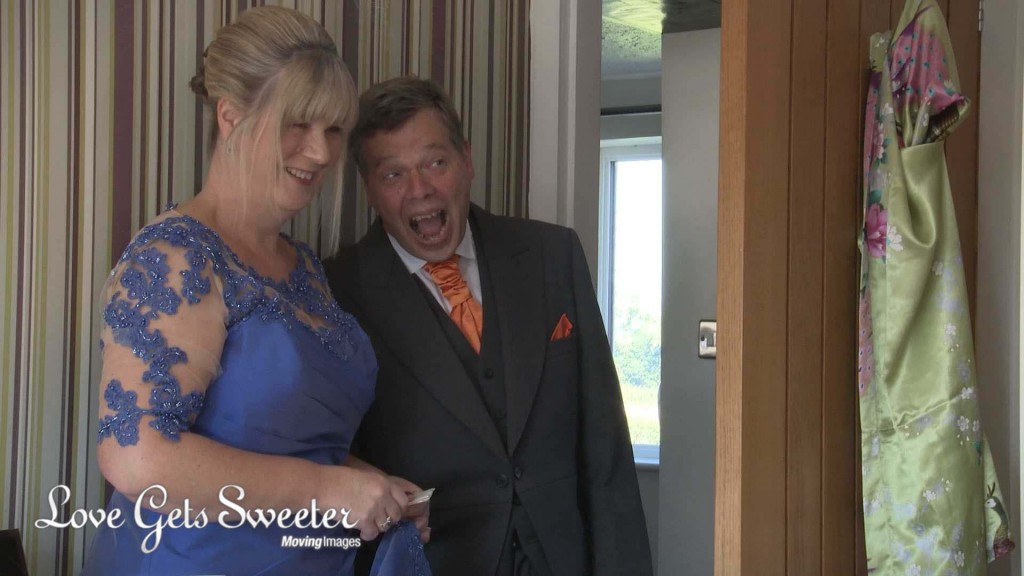 A dad walks in and gasps as he sees his daughter the bride for the first time in her wedding dress in Cheshire. Captured on the wedding video by wedding videographer Love Gets Sweeter
