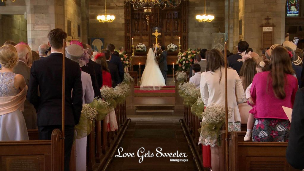 the bride and groom light a candle during the wedding ceremony at st johns church in broughton Preston