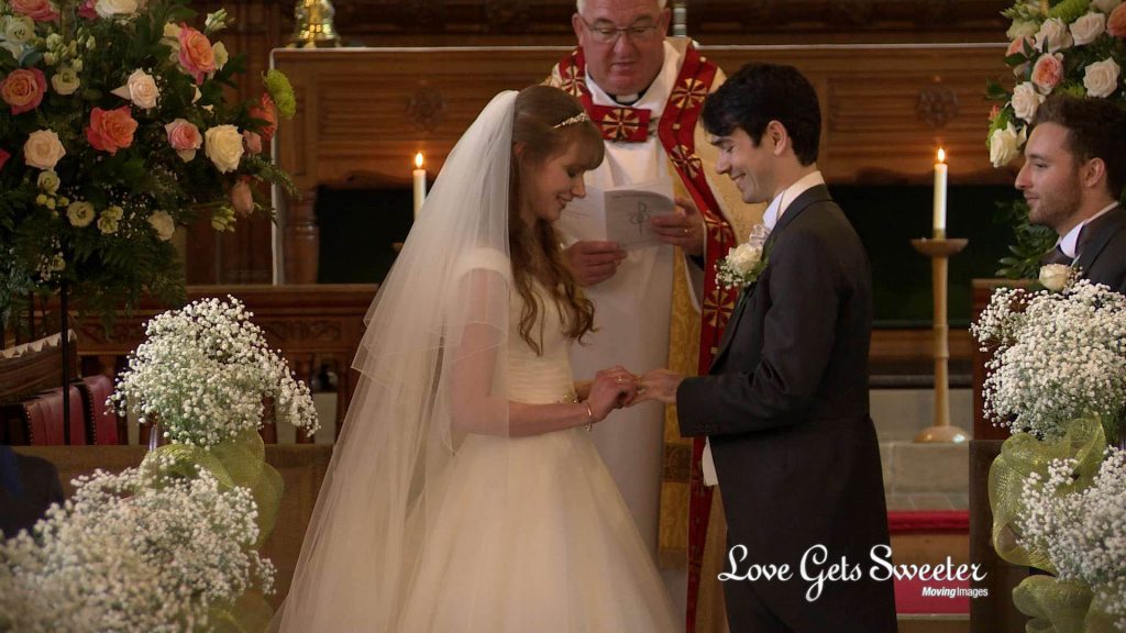 bridget and ben the bride and groom exchange wedding rings at st johns church preston in front of their wedding videographer