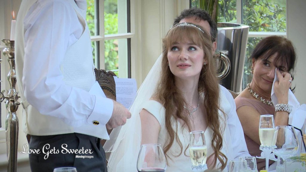 the bride bridget listens to her dads emotional wedding speech and you can see the mother of the groom wiping away tears on the wedding video at mitton hall