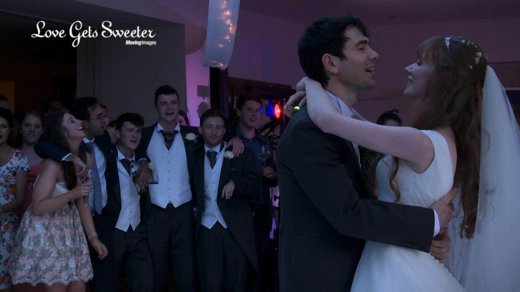 wedding guests sing along with the wedding band during the first dance on this mitton hall wedding video
