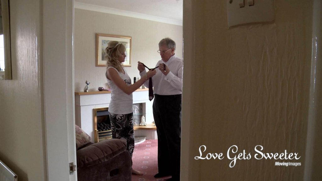 bride helping dad with tie wedding morning