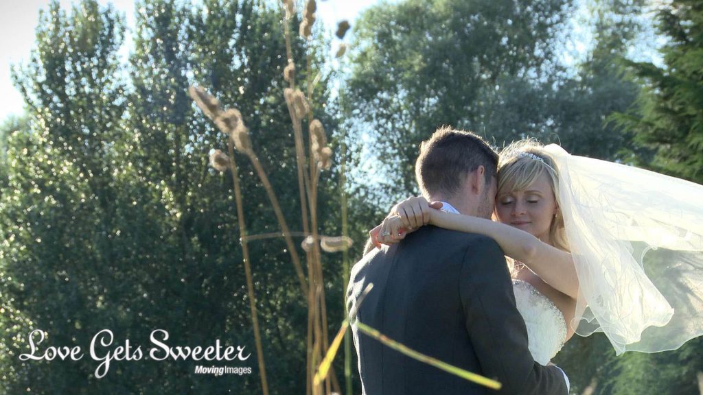 bride and groom having photos in the long grass at Malkins Bank Golf Club wedding