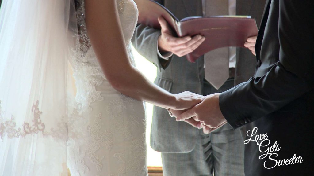 bride and groom holding hands during their wedding ceremony at armathwaite hall caught on the wedding video