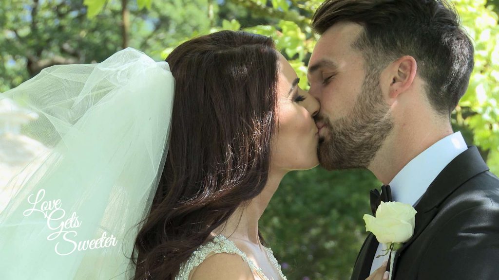 bride and groom sharing a kiss under the try out of the summer sun