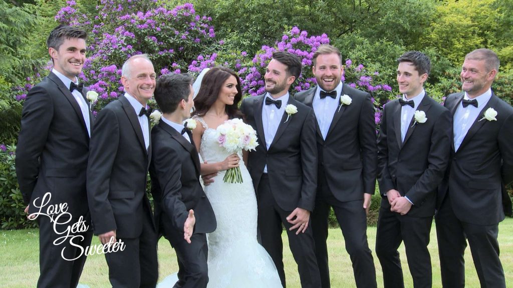 A bride and the groomsman having a fun wedding photo taken with the guys wearing classic black and white