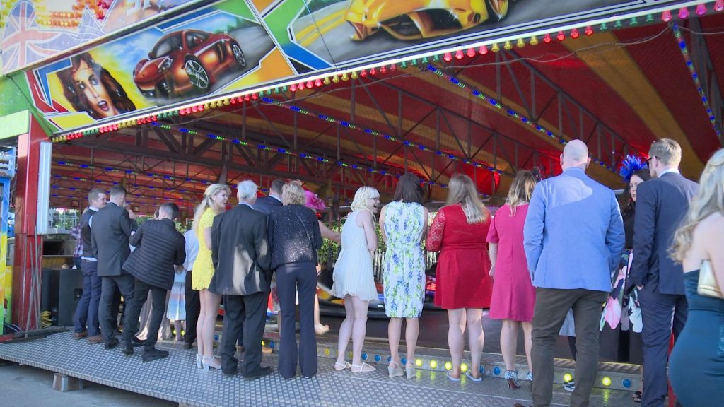 wedding guests waiting to have a go on the fairground dodgem bumper cars 