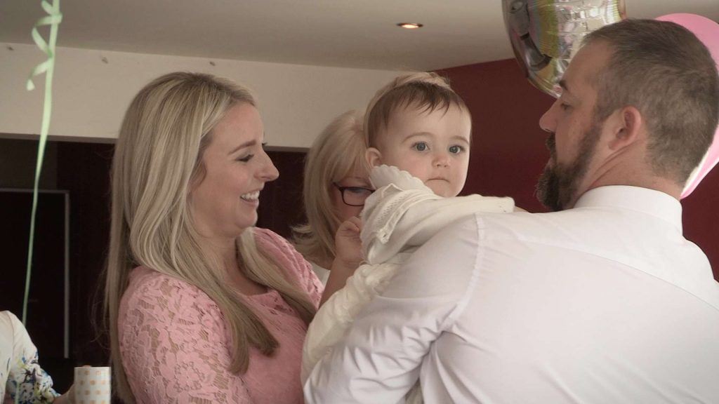 tired baby girl at her christening getting lots of fuss on the video