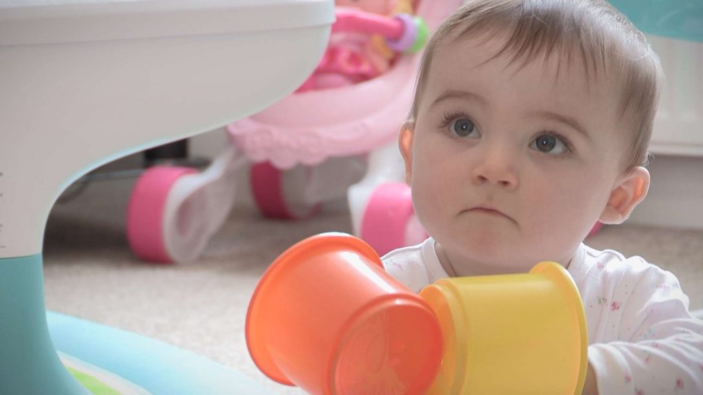baby charlotte playing with stacking blocks at home in Ryhl with her Mum and Dad before her Christening