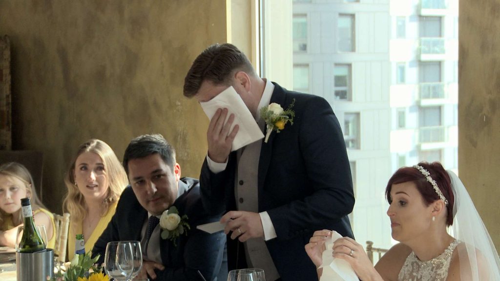 a video still of the groom wiping away his tears after an emotional part of his wedding speech