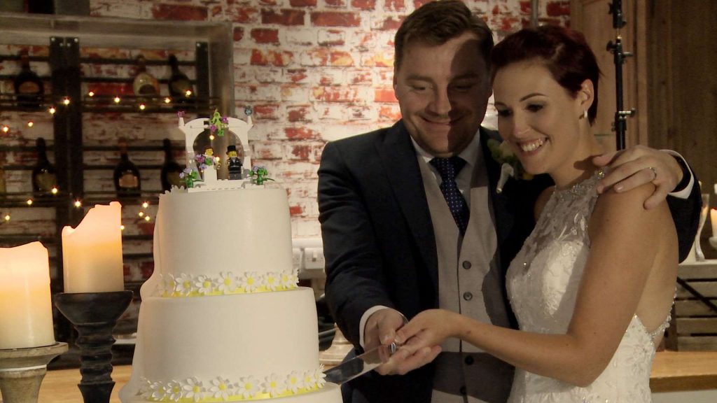 a simple white cake with lego cake topper is ready for the cake cutting