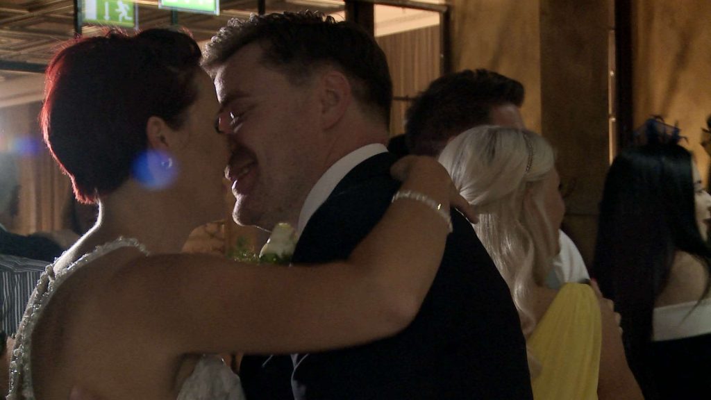 the bride and groom have a kiss on the black and white dancefloor at on the 7th