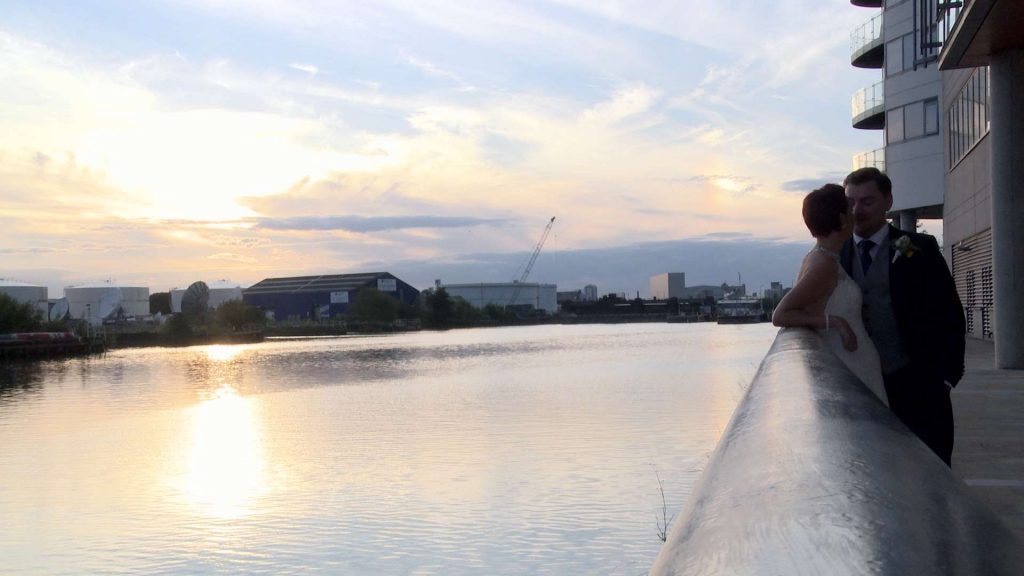 on the end of the wedding video the couple enjoy relaxing by the river for wedding photos