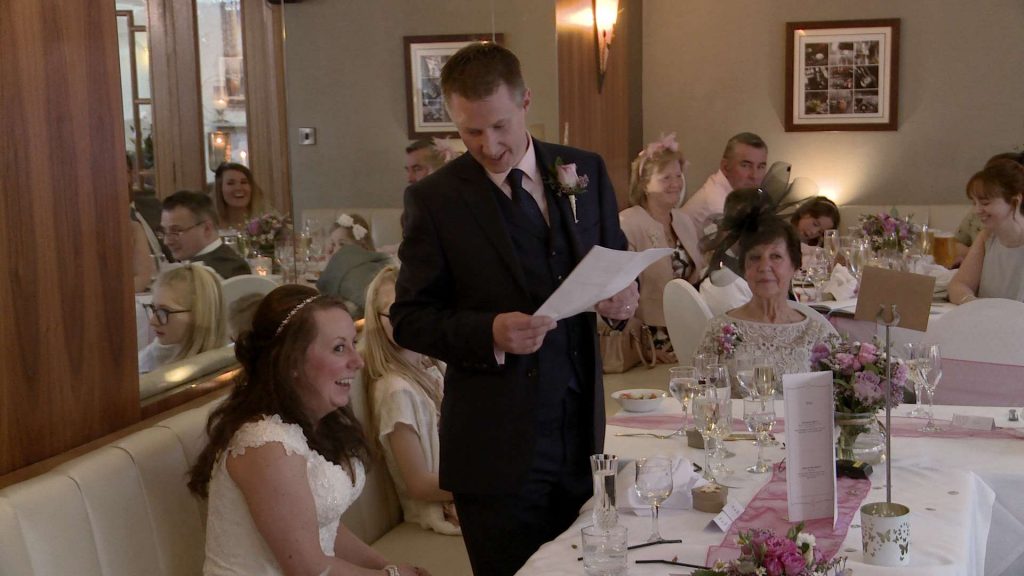 the groom looks down at his bride as he shares his wedding speech with guests at the Wordsworth Hotel