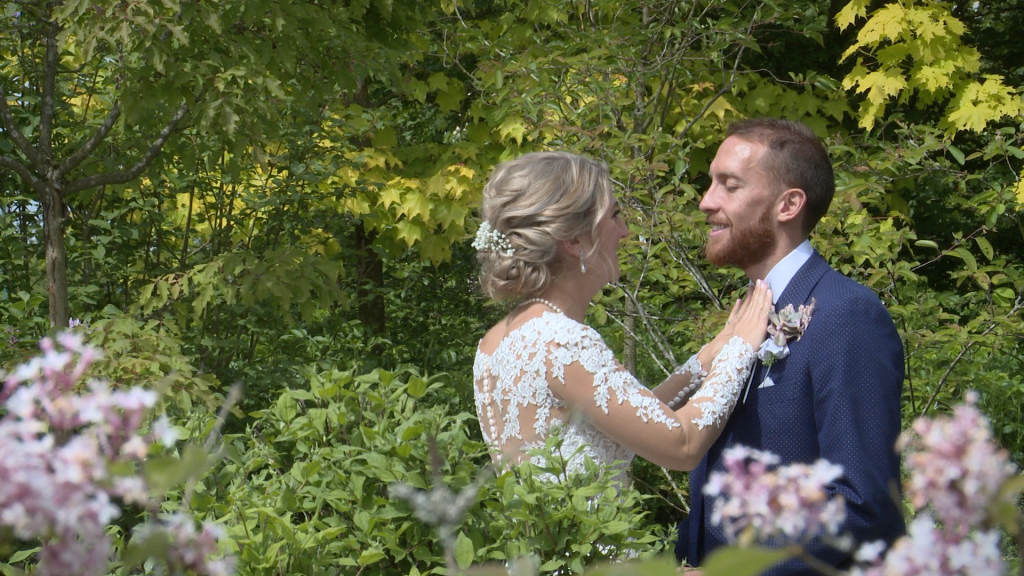 the bride checks the grooms bow tie looks nice and straight before they pose for their wedding photos in the gardens at Styal Lodge in Cheshire