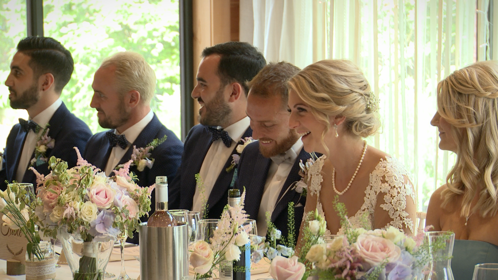 the bridal party laugh on their vintage inspired top table as the father of the bride delivers his speech at Styal Lodge