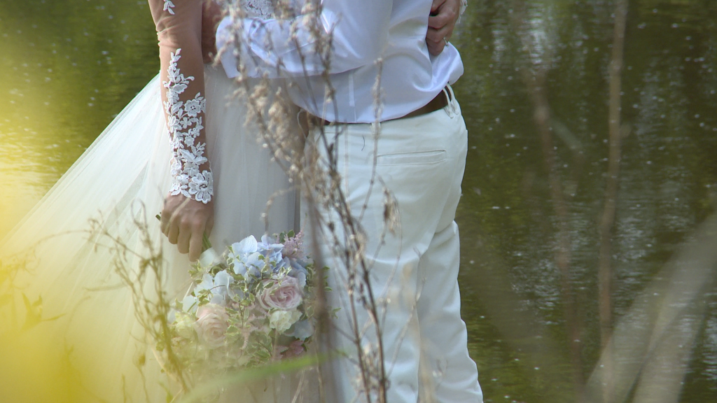 a close up shot of the brides lace sleeve of her wedding dress and pretty pink, white and blue bouquet at Styal Lodge in Cheshire