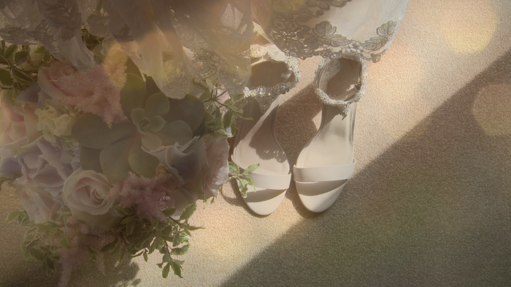 a stunning hand tied informal garden style bridal bouquet sits next to a pair of bridal sandals
