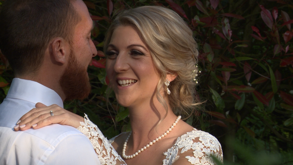 a bride rests her hand on her grooms shoulder as she laughs during wedding photos at Styal Lodge