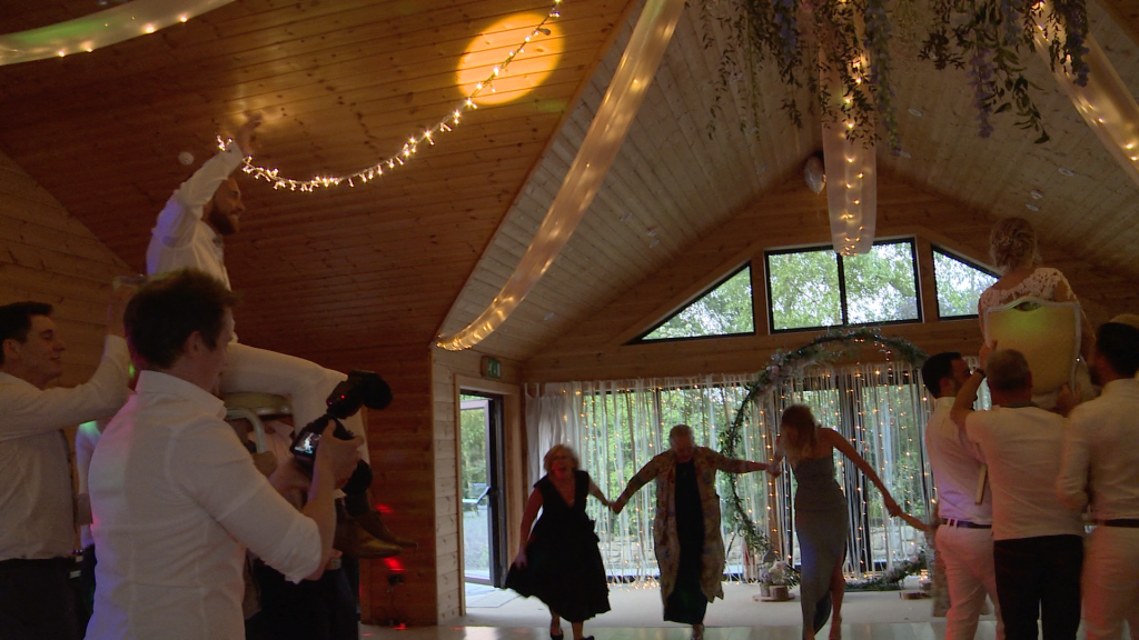 the bride and groom honour a traditional jewish dance and are lifted up on chairs by the groomsmen to celebrate them being married at Styal Lodge in Cheshire