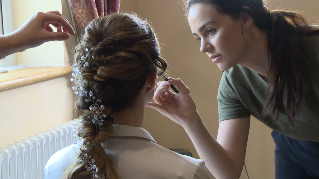 make up artist Caitlin Helsby from Liverpool peaches and cream applies make up to the bride in the living room of her cottages in liverpool