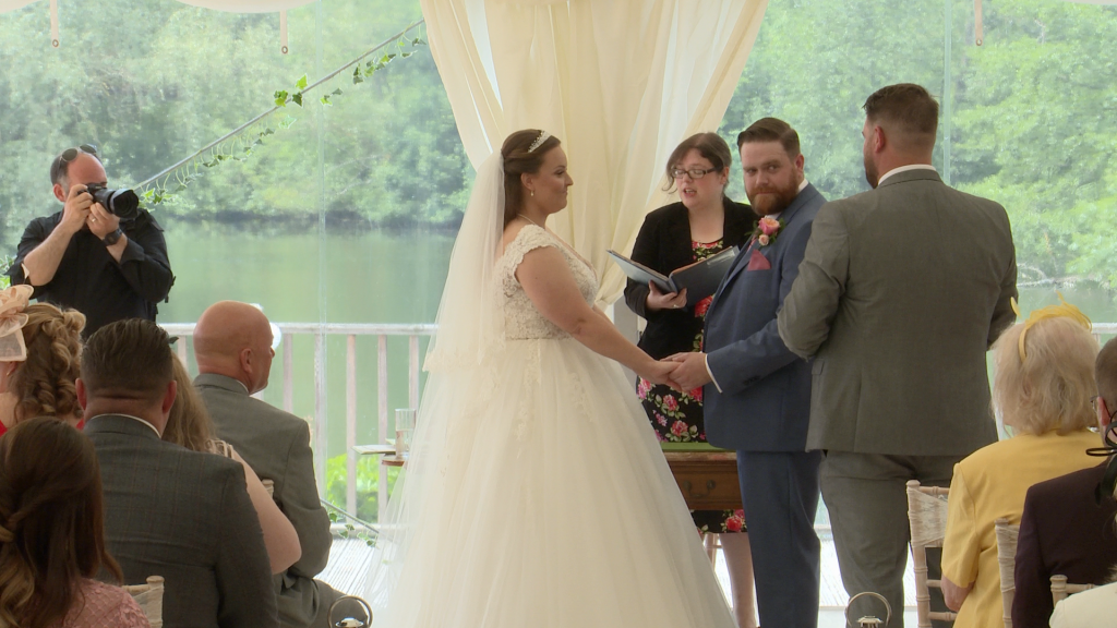 the groom shoots the best man a funny look as he gets ready to give them their wedding rings