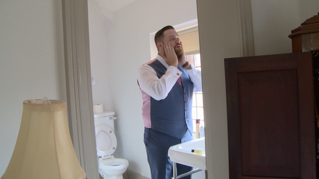 the groom gives his beard a smooth down in the bathroom at thornton manor
