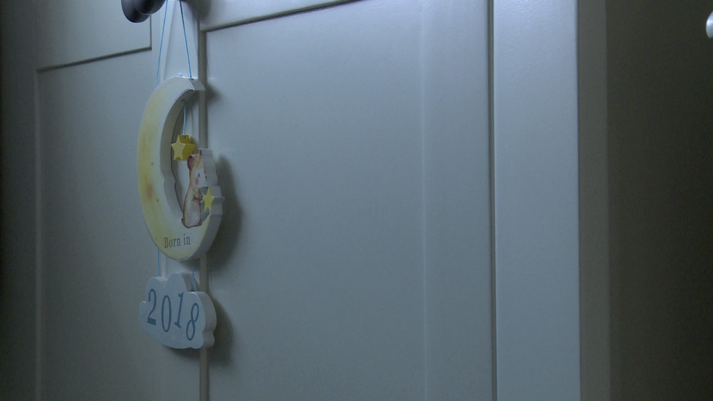 a moon trinket hangs on a wardrobe with born in 2018 written on the cloud below