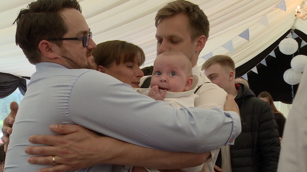 a video captures a big family hug with a baby boy Archie in the middle looking confused at his christening party
