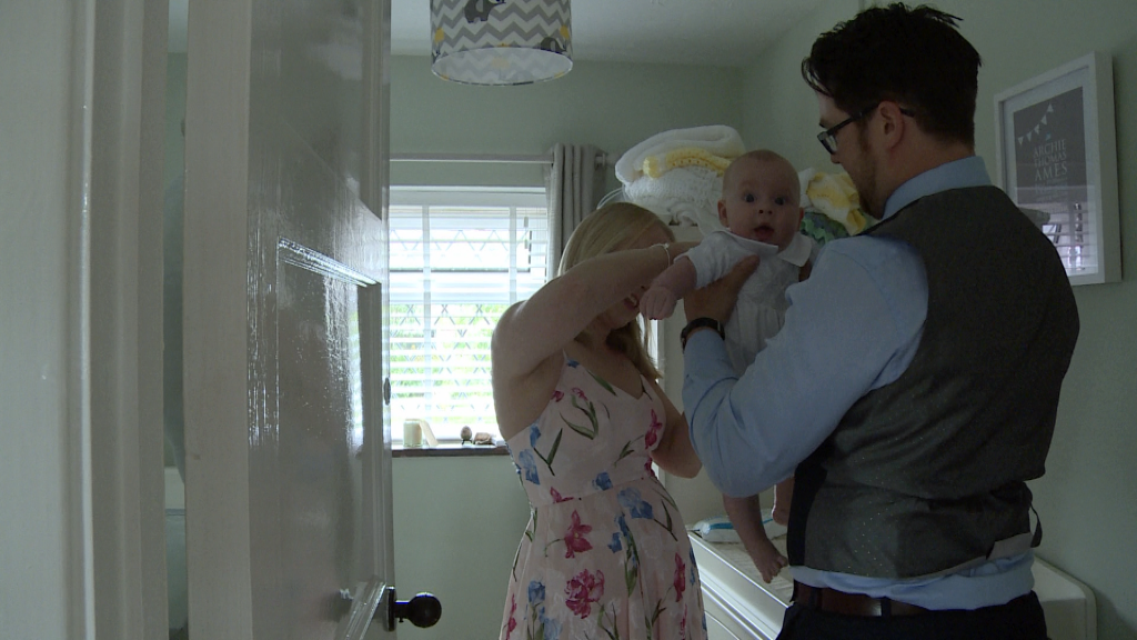 mum and dad work together to get their baby boy dressed and ready for his christening in warrington captured on video