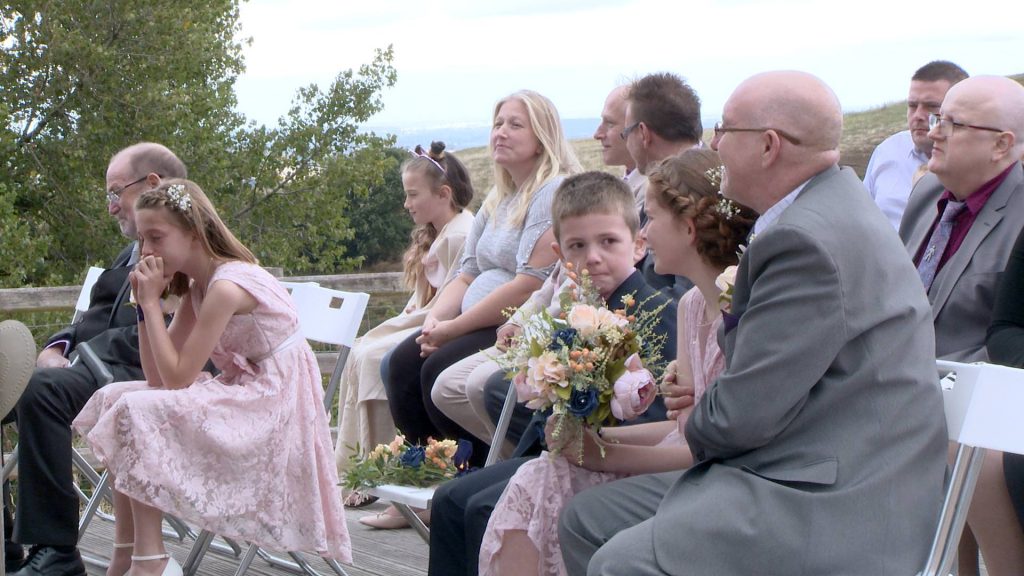the wedding videographer caught a shot of the bride and grooms children crying and getting emotional during their outdoor ceremony
