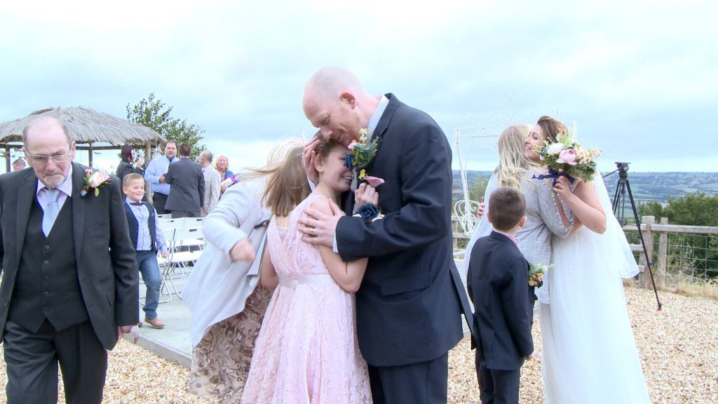 a dad hugs his daughter close after he's gotten married at Abels Harp