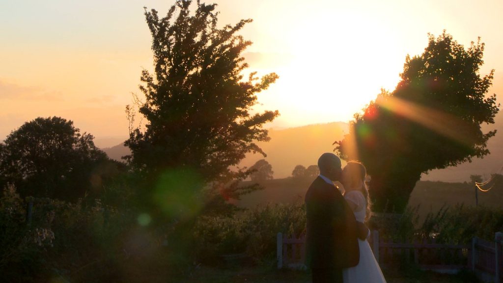a bride and groom pull each other in close and share a kiss for their wedding video at their Shrewsbury wedding