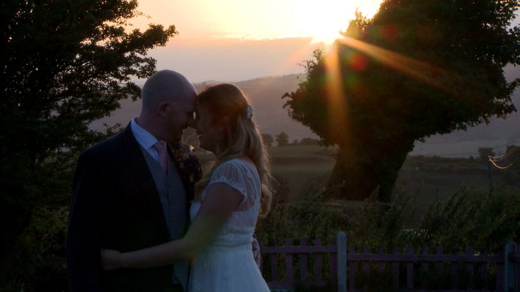 a bride rests her head on her grooms during a photography couples shoot on their wedding day outside Abel's Harp